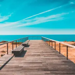 Drewniany pomost prowadzi do oceanu. Idealne miejsce, by sprawdzić, jaka jest portugalia temperatura wody i zanurzyć się w błękit.