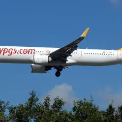 Samolot Pegasus Airlines z napisem "flypgs.com" na kadłubie, gotowy do lądowania. W bagażniku rejestrowanym czeka na pasażerów.