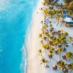 Rajska plaża na Zanzibarze z turkusową wodą, białym piaskiem, palmami i leżakami. Idealne miejsce, kiedy na Zanzibar.