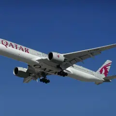 Samolot Qatar Airways z wysuniętym podwoziem, gotowy do lądowania. Idealny do przewozu bagażu podręcznego.