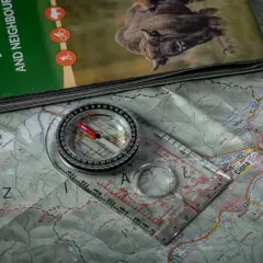 Kompas i mapa turystyczna, idealne do nauki, jak korzystać z kompasu w terenie.