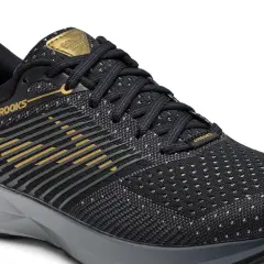 Czarne buty do biegania Brooks z złotymi detalami. Idealne, gdy zastanawiasz się, jakie buty do biegania wybrać.