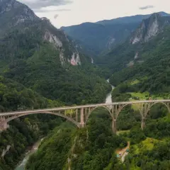 Most Đurđevića Tara, jeden z najpiękniejszych widoków Czarnogóry, w otoczeniu zielonych gór i rzeki.