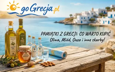 Oliwa, miód i ouzo – to co warto przywieźć z Grecji. Na drewnianym stole, na tle greckiej wioski, leżą butelki oliwy, miodu i ouzo.