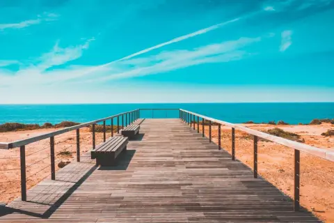 Drewniany pomost prowadzi do oceanu. Idealne miejsce, by sprawdzić, jaka jest portugalia temperatura wody i zanurzyć się w błękit.