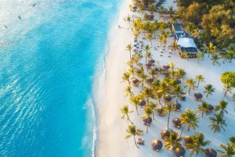 Rajska plaża na Zanzibarze z turkusową wodą, białym piaskiem, palmami i leżakami. Idealne miejsce, kiedy na Zanzibar.