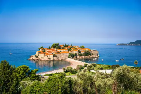 Wyspa Sveti Stefan, perła w koronie tego, co warto zobaczyć w Budvie, otoczona turkusowym morzem.