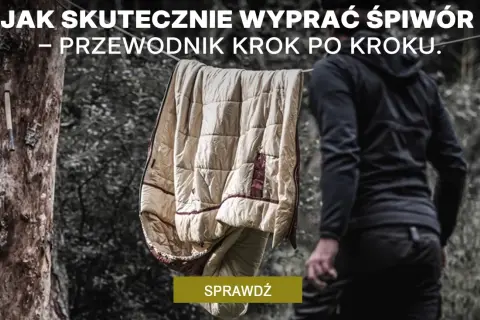 Jak prać śpiwór? Przewodnik krok po kroku. Śpiwór schnie na sznurku, a obok stoi osoba w czarnej bluzie.
