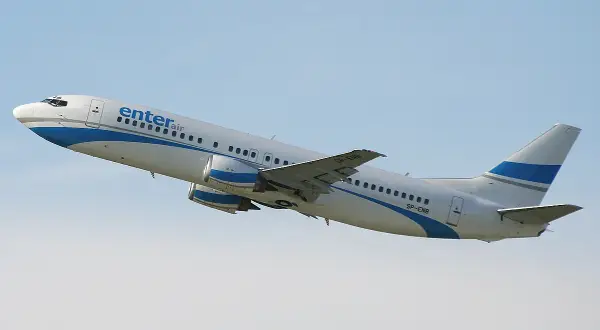 Samolot Enter Air Boeing 737 wznoszący się na tle błękitnego nieba.