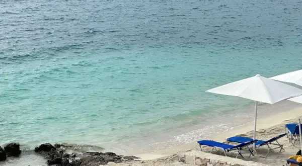 Piękna, słoneczna albania pogoda sierpień. Turkusowe morze, piaszczysta plaża z leżakami i parasolami.