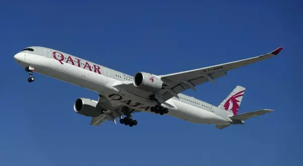 Samolot Qatar Airways z wysuniętym podwoziem, gotowy do lądowania. Idealny do przewozu bagażu podręcznego.