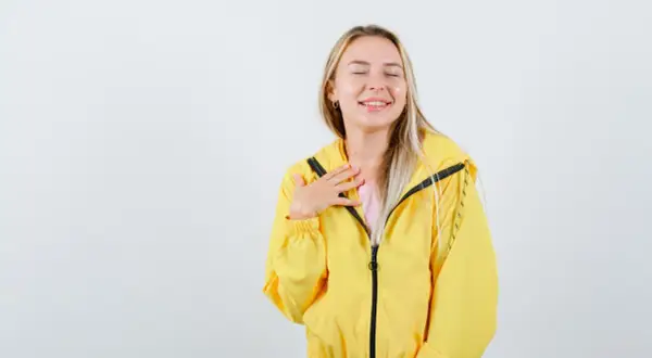 Uśmiechnięta dziewczyna w żółtej kurtce softshell. Dowiedz się, jak prać softshell, by zachować jego właściwości.
