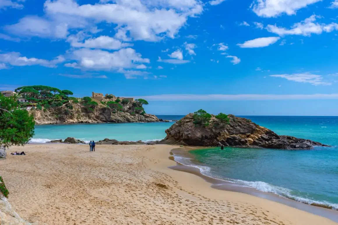 Piękna plaża z turkusową wodą i skalistymi wysepkami. Idealne miejsce na relaks i odkrywanie uroków Costa Brava.