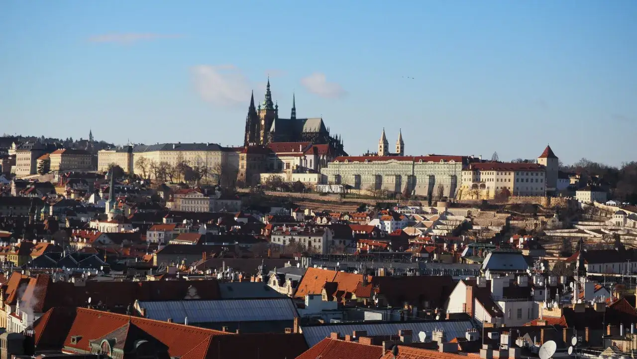 Widok na praskie dachy z g&oacute;rującym nad nimi kompleksem zamek na hradczanach.