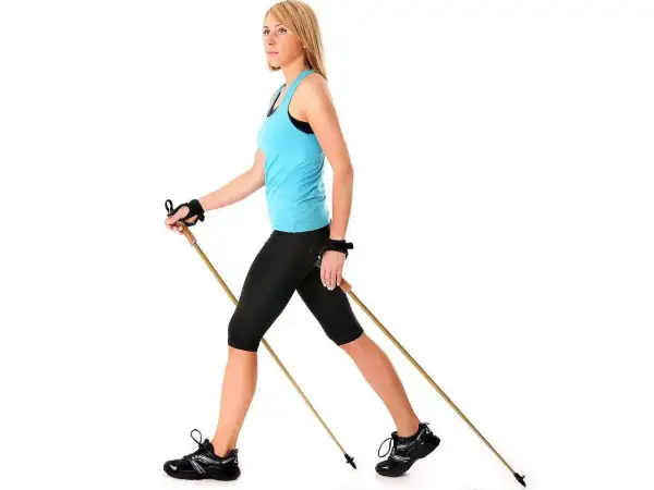 Kobieta ćwiczy nordic walking. Dowiedz się, jak dobrać kije do nordic walking, by trening był efektywny i bezpieczny.